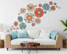 a living room with a couch, table and flower wall decal on the wall