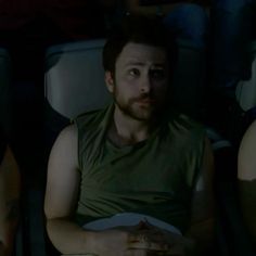 two men sitting next to each other at a movie theater, one with his eyes closed