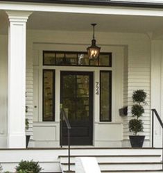 the front door of a white house with steps leading up to it