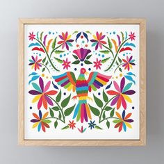 the colorful bird is surrounded by flowers and leaves on a white background, framed in a wooden frame