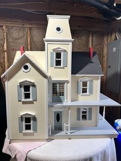 a doll house sitting on top of a table in front of a wall under construction