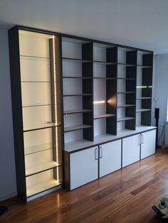 an empty room with some bookshelves and lights on the wall behind them,