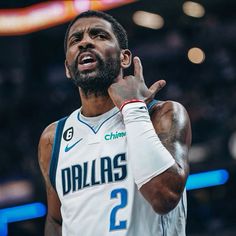 a basketball player holding his hand up in the air while making a gesture with his right hand