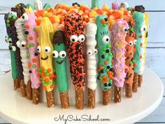 a cake decorated with many different types of candy sticks and eyes on top of each other