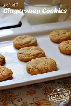 the best ginger snap cookies on a white platter next to a glass of milk