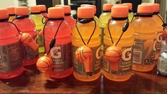 six orange sports water bottles lined up on a table