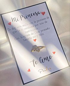 a card with an engagement ring on it and the words in spanish are written below