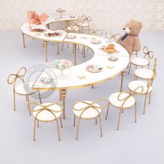 a teddy bear sitting at a table with chairs