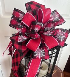 a red and black bow on top of a lantern