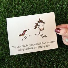 someone holding up a card with a drawing of a unicorn on it