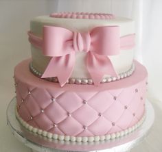 a three tiered cake with pink and white icing