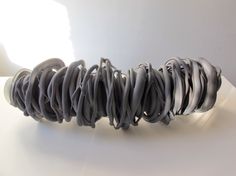 a white table topped with an object made out of gray plastic tubes and wires on top of it