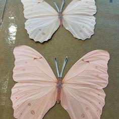 two paper butterflies sitting on top of a table