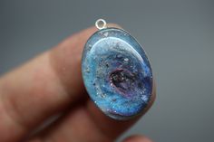 "If you are searching for a truly unique and breathtaking memorial gift, look no further than our milky way pendants! These cremation galaxy necklaces are handcrafted for you with the ashes you provide. Each swirling, shimmery galaxy is set in a 18x25mm oval sterling silver pendant and hangs from your choice of sterling silver chain. These galactic necklaces are built in layers to give them as much depth as possible. In the comments box, please note how defined you would like the \"swirl\" to be Paw Print Ring, Cremation Ring, Galaxy Necklace, Ashes Necklace, Memorial Ring, Urn Pendant, Urn Jewelry, Urn Necklace, Ashes Jewelry