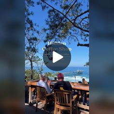 two men sitting at a table with the ocean in the background and words hidden coffee shop