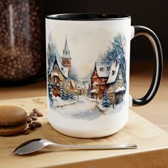 a coffee mug sitting on top of a wooden table next to a spoon and cup