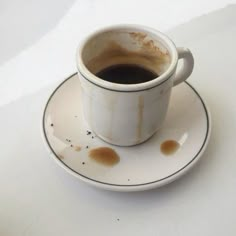 a dirty cup of coffee sitting on top of a saucer