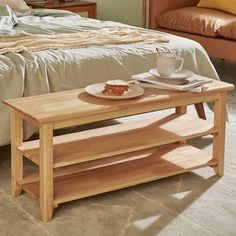 a wooden table sitting in front of a bed