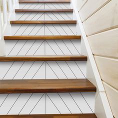 wooden steps leading up to the top of a set of stairs with white painted walls