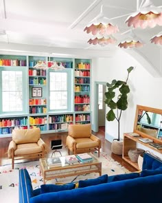 a living room filled with lots of furniture and bookshelves full of colorful books