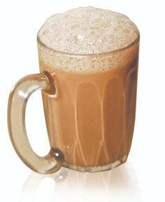 a glass mug filled with liquid on top of a white table