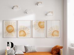 a bedroom with three sun paintings on the wall