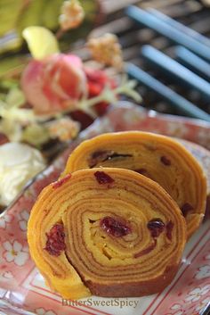 two pieces of pastry on a plate with flowers in the background