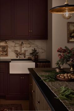 a kitchen with dark wood cabinets and marble counter tops, along with an island in the middle