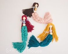 three tassels with different colors and designs on them, one is blue, the other is pink