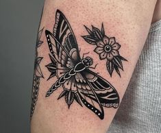 a woman's arm with a butterfly and flower tattoo on the left side of her body