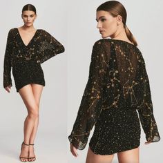 a woman in a black dress with gold stars on it and the back of her body