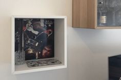 a shelf with some wine glasses on top of it next to a wall mounted cd player