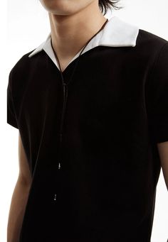 Experience a fresh take on a classic with our Slim Contrast Collar Zippered Polo Shirt, a sophisticated twist on everyday style. Crafted with attention to detail, this polo shirt features a sharp contrast collar and a contemporary zippered placket. The soft blend of premium cotton and nylon ensures both comfort and durability, while the juxtaposition of black and white adds a dynamic visual appeal. Its loose fit allows for easy movement and an on-trend, nonchalant vibe that transitions smoothly Casual Johnny Collar Tops For Work, Elegant Summer Polo Shirt For Workwear, Classic Collared Tops For Casual Gatherings, Black Collared Top For Casual Gatherings, Classic Johnny Collar Tops For Everyday, Elegant Spring Polo Shirt For Workwear, Elegant Spring Polo Shirt For Work, Elegant Spring Workwear Polo Shirt, Modern Polo Collar Tops For Workwear