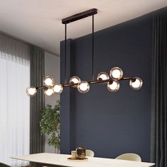 a dining room table with chairs and a light fixture hanging over it's head