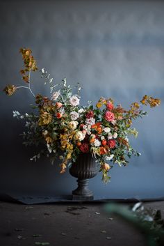 a vase filled with lots of flowers on top of a table