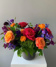 a vase filled with colorful flowers on top of a white table