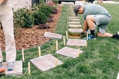 two men are working on some steps in the grass