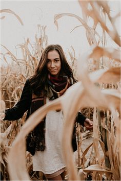 a woman standing in the middle of a corn field