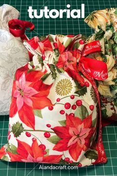 two bags with poinsettis on them sitting on a cutting board