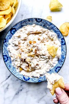 a blue and white bowl filled with potato chips next to a bowl of tortilla chips