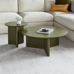 two tables sitting next to each other in front of a white couch and coffee table