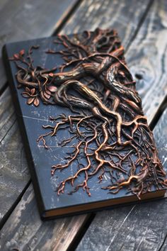 a book that is sitting on top of a wooden table with tree roots in it