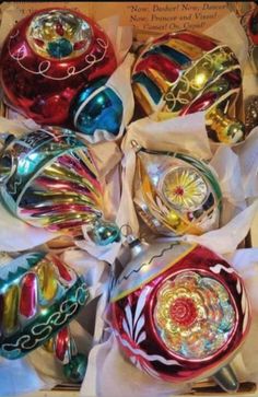 many different colored ornaments are in a box