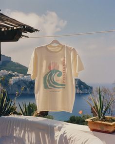 Seize the surf in our Positano 1980 Tee. For the girl who makes waves both on the beach and off, this is your summer statement tee. Unisex soft cotton crew neck t-shirt featuring a Positano Italy Surf Camp graphic printed on the front. Fabrics: 100% cotton, 6 oz Made in: LA Statement Tees Aesthetic, Beach Graphic Crew Neck T-shirt, Retro Surfing T-shirt For Beach Season, Surf Brands Clothing, Casual Beach T-shirt With Graphic Design, Summer Cotton T-shirt For Surfing, Retro T-shirt With Back Print For Summer, Beach Crew Neck T-shirt With Graphic Design, Retro Summer Tops With Back Print