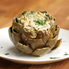 an artichoke on a white plate with the words easy baked artichoke