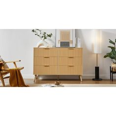 a living room scene with focus on the chest of drawers and chair in the foreground