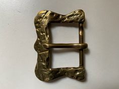 a gold metal buckle on a white wall