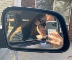 a woman taking a selfie in the side view mirror