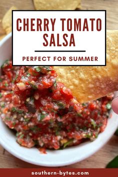 a person dipping salsa into a bowl with tortilla chips on the side and text overlay reading cherry tomato salsa perfect for summer