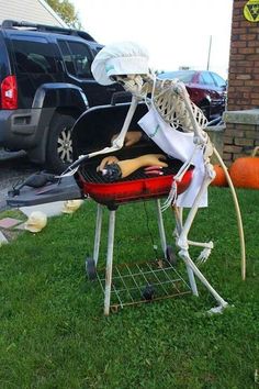 a skeleton sitting on top of a grill in the grass